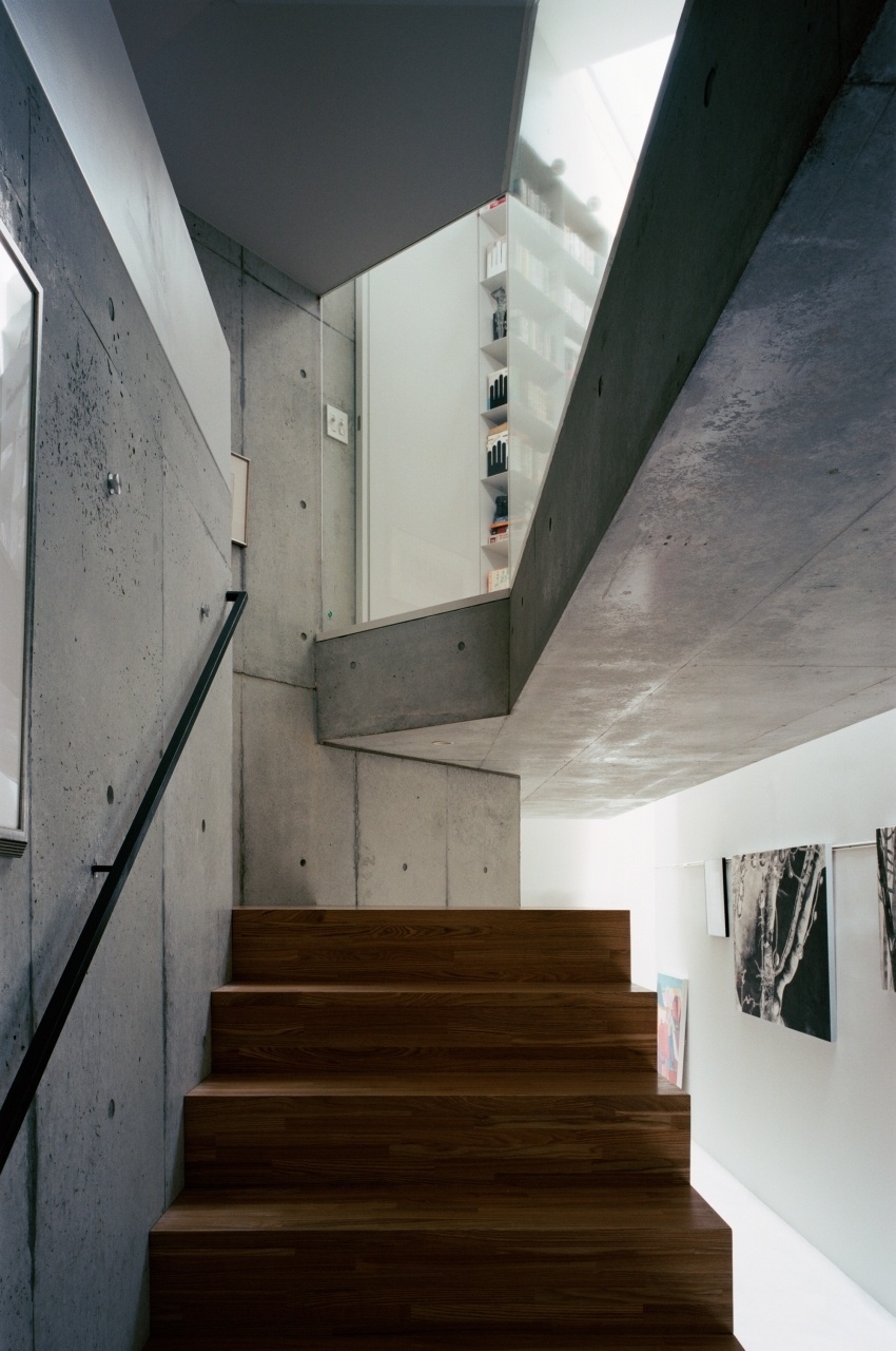 A escadaria que vai da galeria de entrada ao primeiro pavimento revela uma arquitetura de lajes de concreto espessas e cartesianamente recortadas, com detalhes de paredes e forros que expõe o material estrutural, em sua forma lixada. A escada recebe palitos de eucalipto tratado, para contrastar com a temperatura fria do concreto e enriquecer o aspecto rústico e natural dos interiores. A Casa TN fica em Tóquio, no Japão, e foi projetada por Tsuyoshi Ando - Kai Nakamura/ Divulgação