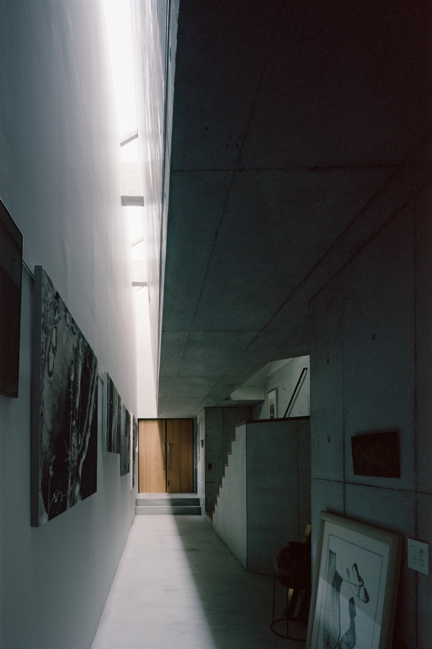 A luz natural que ilumina as gravuras da moradora da Casa TN, em Tóquio, entra por uma extensa claraboia em caixilhos de alumínio. A parede-empena que recebe as gravuras em exibição foi executada em painéis de gesso acartonado. Há espuma de poliuretano (isolante térmico) entre os painéis e a parede externa de fachada, que é de concreto aparente. Projeto do arquiteto japonês Tsuyoshi Ando - Kai Nakamura/ Divulgação