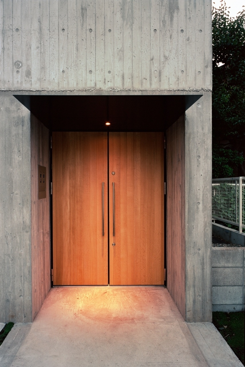 O arquiteto Tsuyoshi Ando escolheu o eucalipto para compor detalhes que aquecem os ambientes e a arquitetura externa, marcados pela sobriedade do concreto aparente. A porta de entrada (foto), os pisos e os lances de escadas são feitos de lenho. A Casa TN fica em Tóquio, Japão - Kai Nakamura/ Divulgação