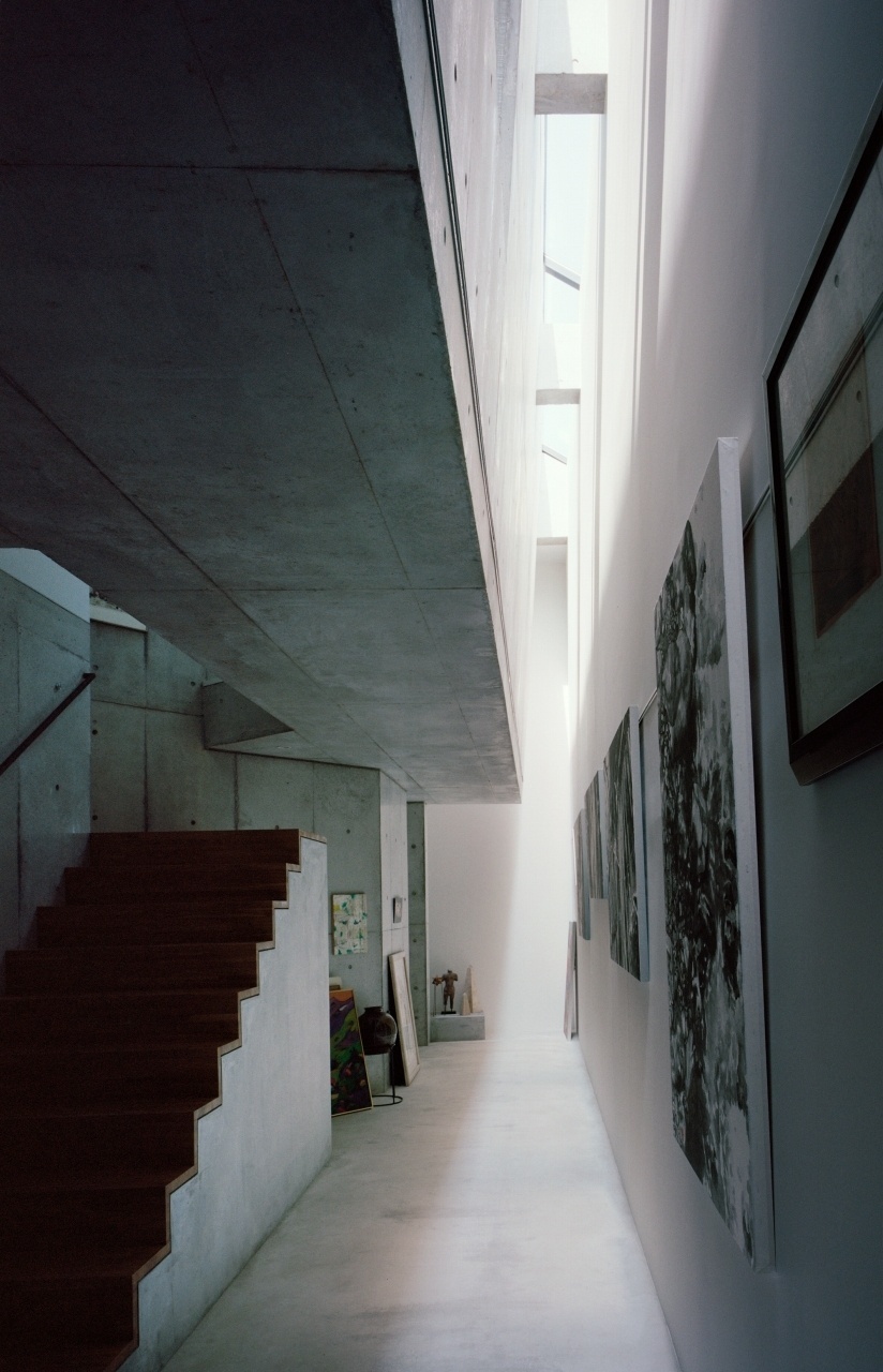 O corredor de entrada se configura como um ambiente especial, que une as duas residências contidas na Casa TN, em Tóquio. Neste triplex, a matrona vive no andar térreo, enquanto o filho ocupa, com sua esposa, os cômodos superiores. O longo corredor lateral foi projetado para ser uma galeria de exposição das gravuras da senhora, distribuídas ao longo de uma enorme parede-empena. Lá de cima, uma claraboia ilumina o espaço com luz natural. O projeto é do arquiteto japonês Tsuyoshi Ando - Kai Nakamura/ Divulgação