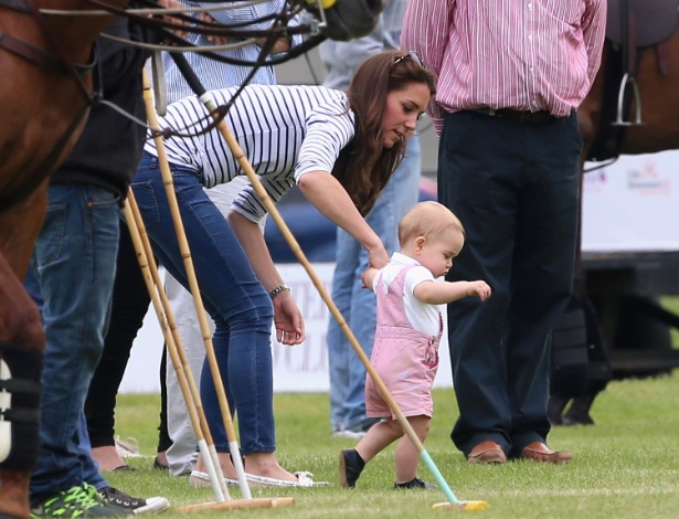 Príncipe George anda com o auxílio da mãe, a Duquesa Kate Middleton, durante partida de polo beneficente na Inglaterra