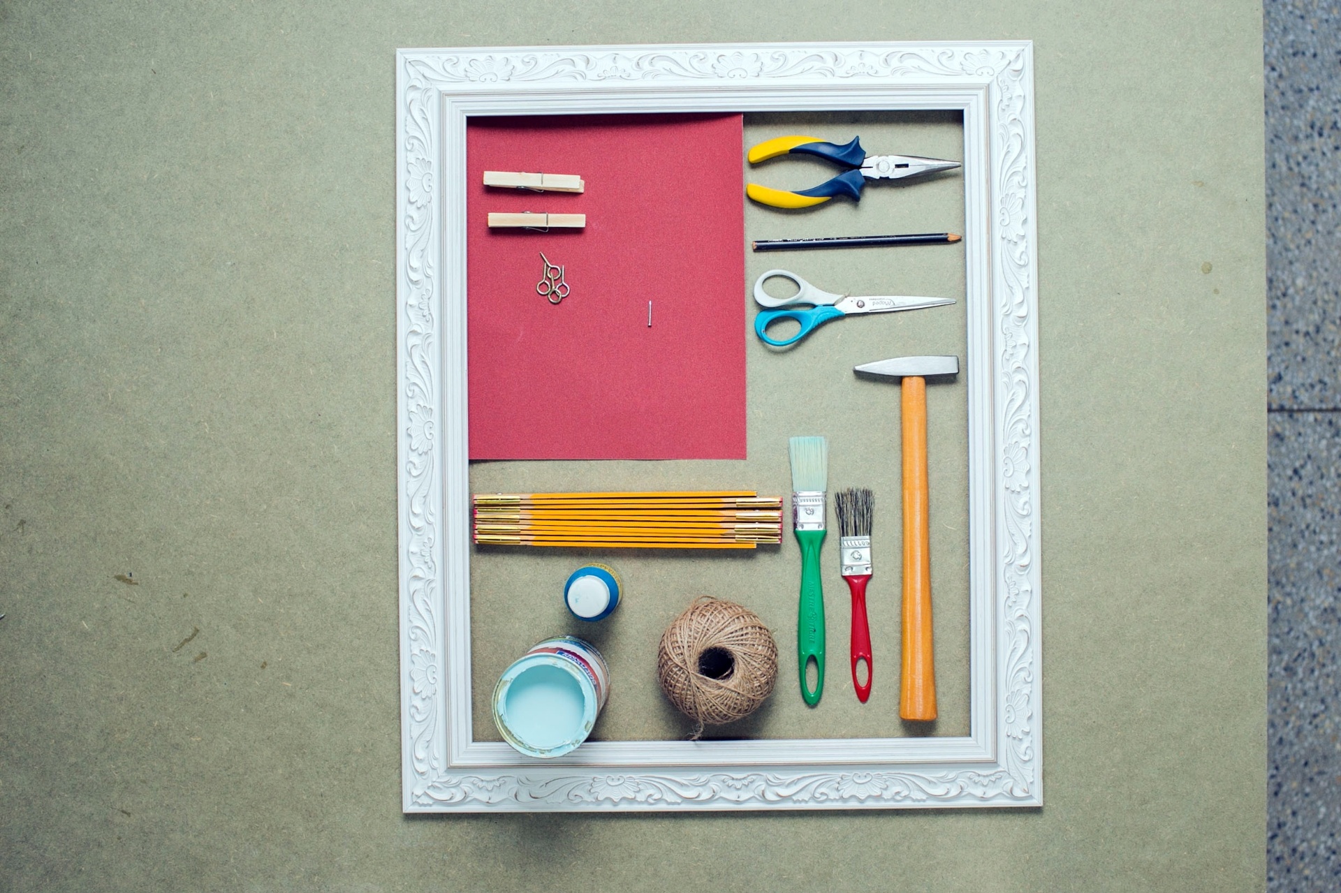 Confira os materiais necessários para fazer o painel de fotos: moldura; lixa para madeira número 220; alicate de ponta chata; pregadores de roupa;  pitão rosca (espécie de parafuso cuja cabeça tem forma de aro) para madeira (16 x 40); prego de aço com cabeça (1,60 mm x 20 mm); lápis preto; tesoura; metro; trinchas (tipo de pincel); martelo de pena reto; tinta para artesanato ou guache ou acrílico; amostra de látex já preparada e cordão - Leonardo Soares/UOL