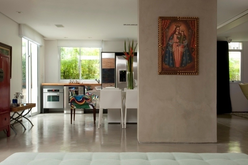 Integrado à cozinha gourmet do apartamento Alto de Pinheiros, em São Paulo, está o living - separado dela apenas por uma coluna estrutural que teve de ser mantida, após a reforma do piso térreo. A coluna é revestida por cimento queimado cinza, neutro e brilhante, assim como o piso. O projeto é dos arquitetos Gabriel Magalhães e Luiz Cláudio Souza - Marcelo Magnani/ Divulgação