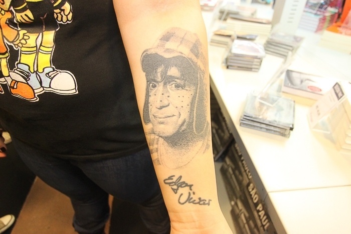 22.jun.2014 - Fã mostra tatuagem do rosto de Chaves no braço em livraria durante participação de Edgar Vivar, famoso por interpretar os personagens Sr. Barriga e Nhonho no seriado - Rodrigo Zerner/AgNews