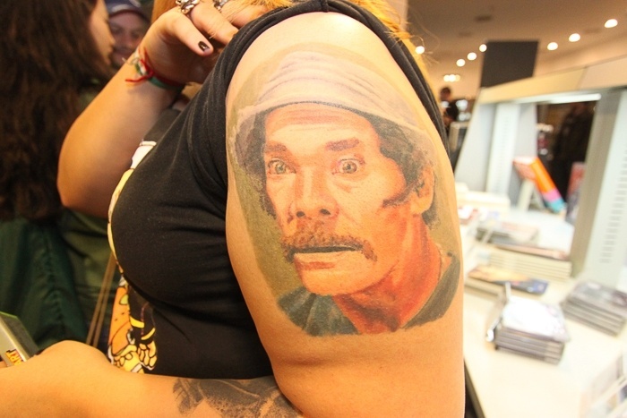 22.jun.2014 - Fã mostra tatuagem do rosto do Seu Madruga no braço em livraria durante participação de Edgar Vivar, famoso por interpretar os personagens Sr. Barriga e Nhonho no seriado - Rodrigo Zerner/AgNews