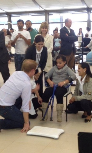 23.jun.2014 - Príncipe Harry se ajoelha e conversa com crianças do hospital e centro de reabilitação Sarah, no Lago norte, em Brasília