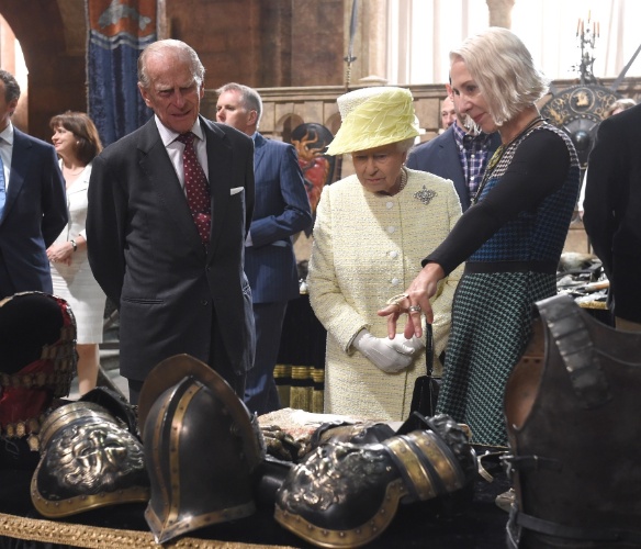 24.jun.2014 - A Rainha Elizabeth 2ª e o marido, o Príncipe Philip, observam as armaduras de "Game of Thrones" durante visita ao set de filmagens da série em Belfast, na Irlanda do Norte