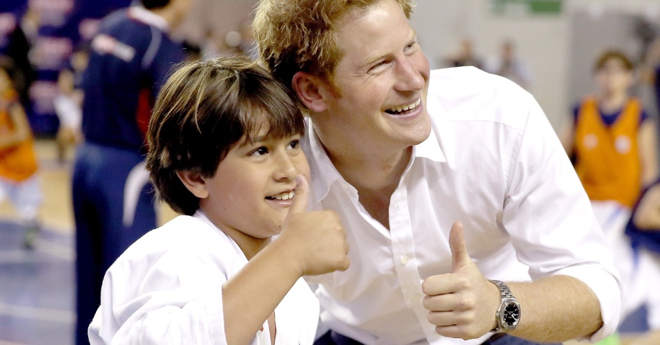24.jun.2014 - Simpático, Príncipe Harry posa com aluno de judô do Minas Tênis Clube, em Belo Horizonte