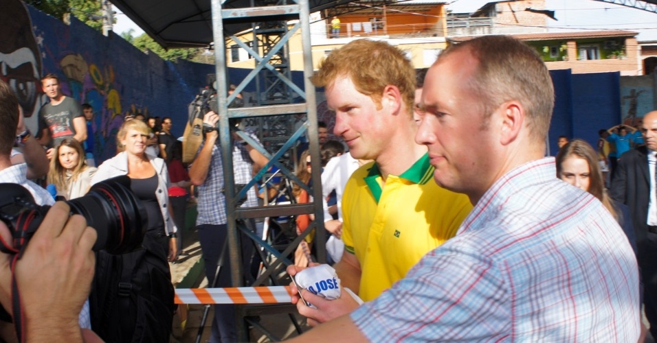 25.jun.2014 - Com a camisa do Brasil, Príncipe Harry joga futebol com crianças de projeto social em Diadema