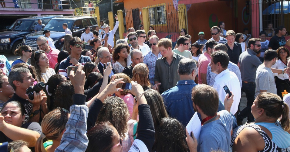25.jun.2014 - Príncipe Harry é cercado por multidão ao visitar a Comunidade Cota 200, em Cubatão, no litoral de São Paulo