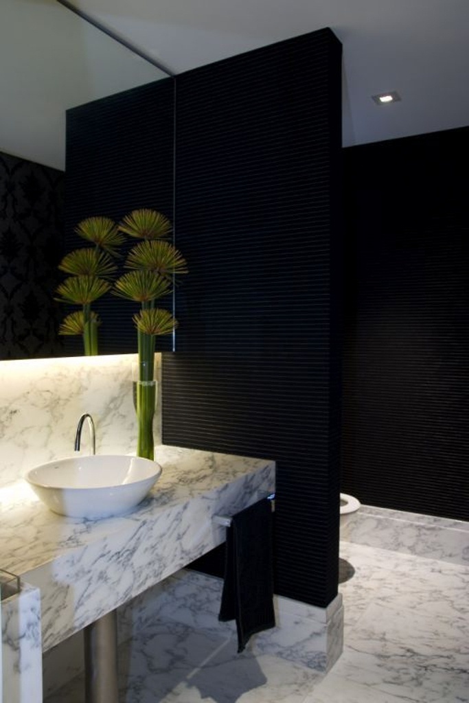 O contraponto entre a parede preta e o mármore claro do piso e da bancada é o diferencial deste lavabo assinado pela arquiteta Ieda Korman. O revestimento escuro ressalta os veios da pedra e acrescenta requinte ao espaço - Divulgação