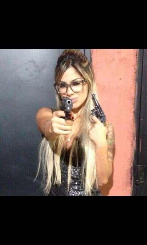 Ex-BBB Vanessa Mesquita posa segurando duas armas