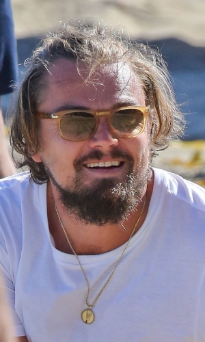6.jul.2014 - Durante partida de vôlei na praia de Malibu, na Califórnia, Leonardo DiCaprio aparece com a barba mais cheia e os cabelos mais compridos, presos em um meio-rabo