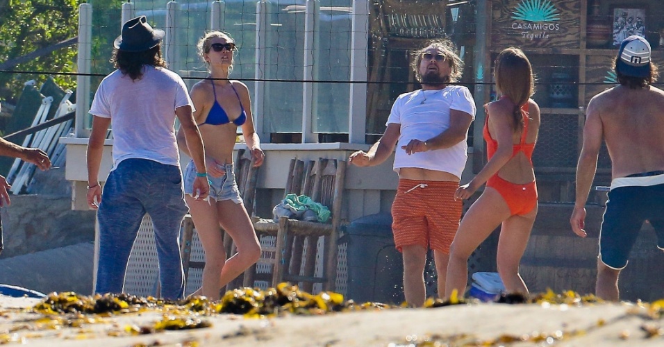 6.jul.2014 - Leonardo DiCaprio joga vôlei na praia em Malibu, na Califórnia, ao lado da namorada, a modelo Toni Garn. O ator acabou deixando um pouco da barriga à mostra durante a partida