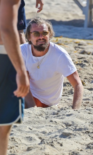 6.jul.2014 - Leonardo DiCaprio senta na areia após jogar vôlei na praia em Malibu, na Califórnia, com a namorada, a modelo Toni Garn