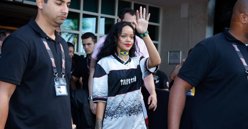 13.jul.2014 - A cantora Rihanna deixa hotel rumo ao Maracanã com uma bandeira do Brasil pintada no pescoço