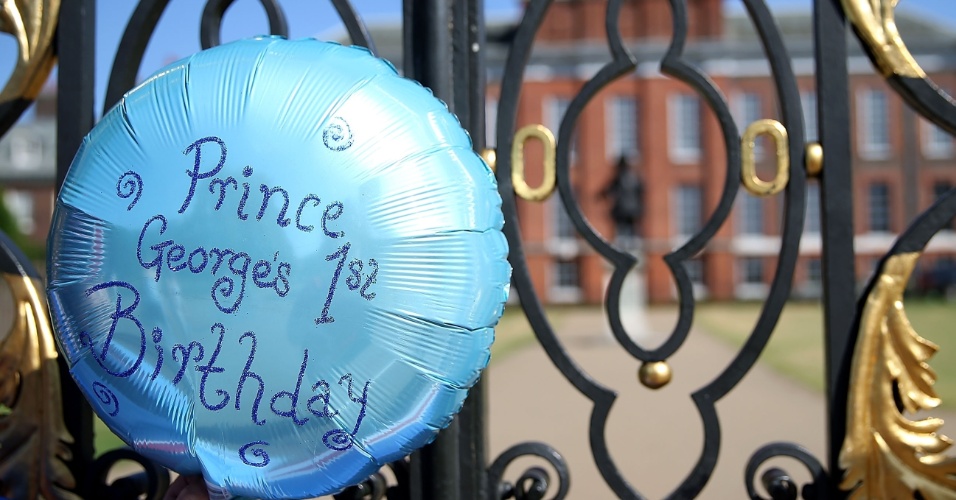 22.jul.2014 - Para comemorar o aniversário de um ano do Príncipe George, admiradores da família real levaram balões e bandeiras para o Palácio de Kensington, em Londres