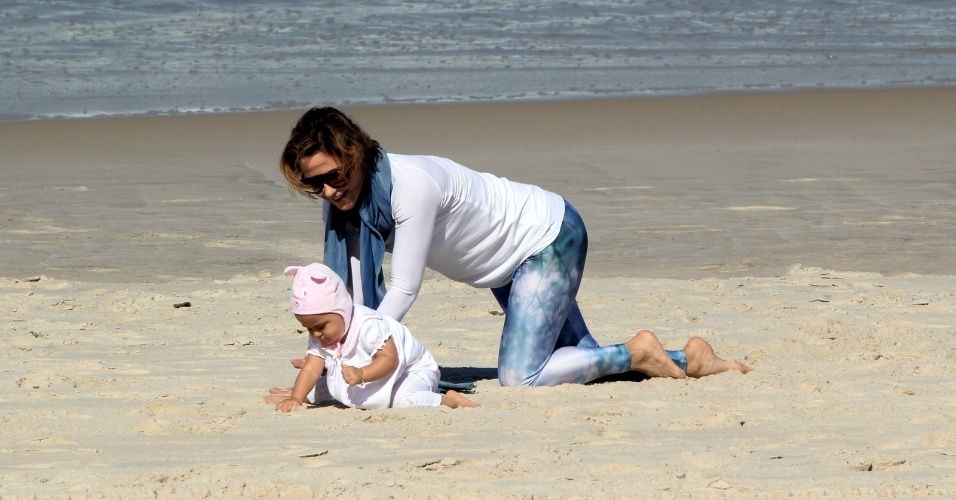 23.jul.2014 - A atriz Guilhermina Guinle brinca com a filha Minna, que usa um gorro de bichinho, na praia de Ipanema, na zona sul do Rio