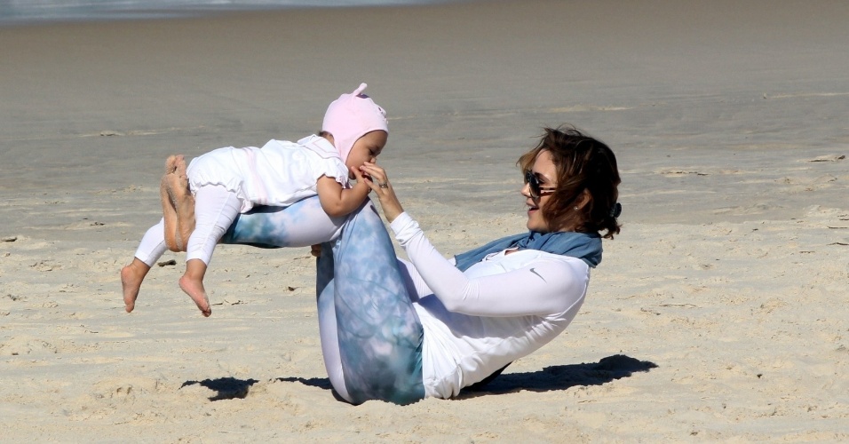 23.jul.2014 - Guilhermina Guinle brinca com a filha Minna na praia de Ipanema, na zona sul do Rio