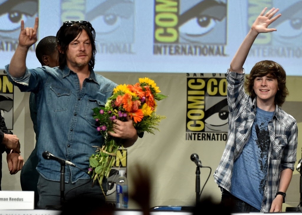 25.jul.2014 - Norman Reedus e Chandler Riggs no painel de "The Walking Dead" na San Diego Comic-Con. Os produtores da série que volta em outubro disseram que de agora em diante a versão televisiva deve se aproximar mais dos eventos narrados nas páginas da HQ, que continua a ser publicada pela Image Comics - Kevin Winter/AFP