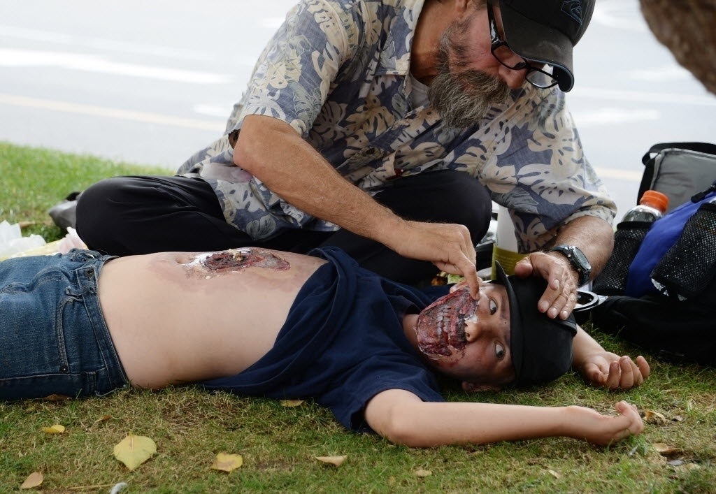 25.jul.2014 - Zumbi retoca sua maquiagem na grama próximo à San Diego Comic-Con - Robyn Beck/AFP