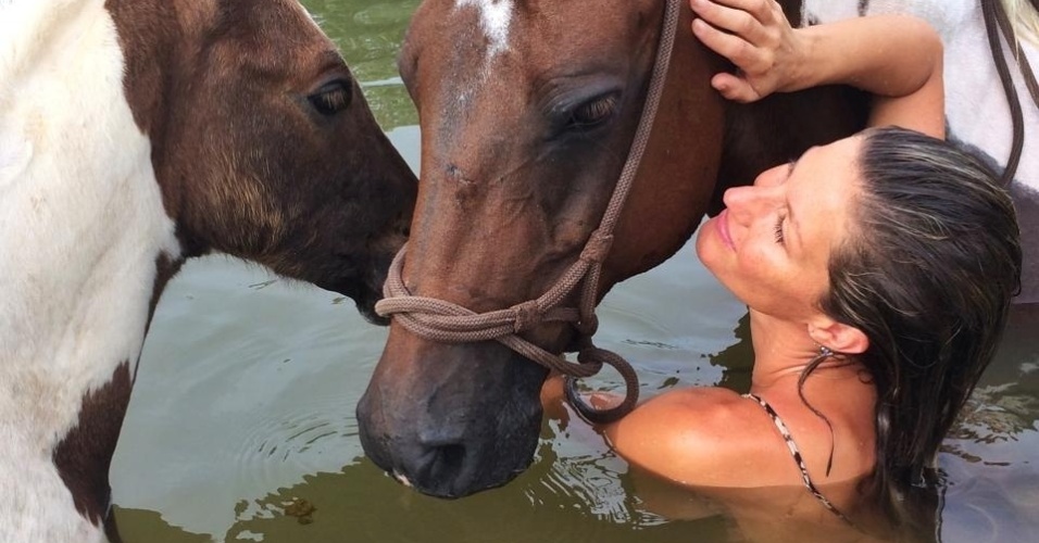 31.jul.2014 - Gisele Bündchen se divertiu ao tomar banho de rio com cavalos. 