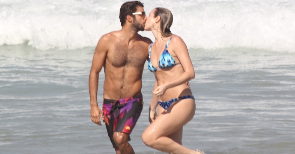 1.ago,2014 - Luana Piovani e o marido Pedro Scooby se beijam ao sair do mar na praia do Leblon