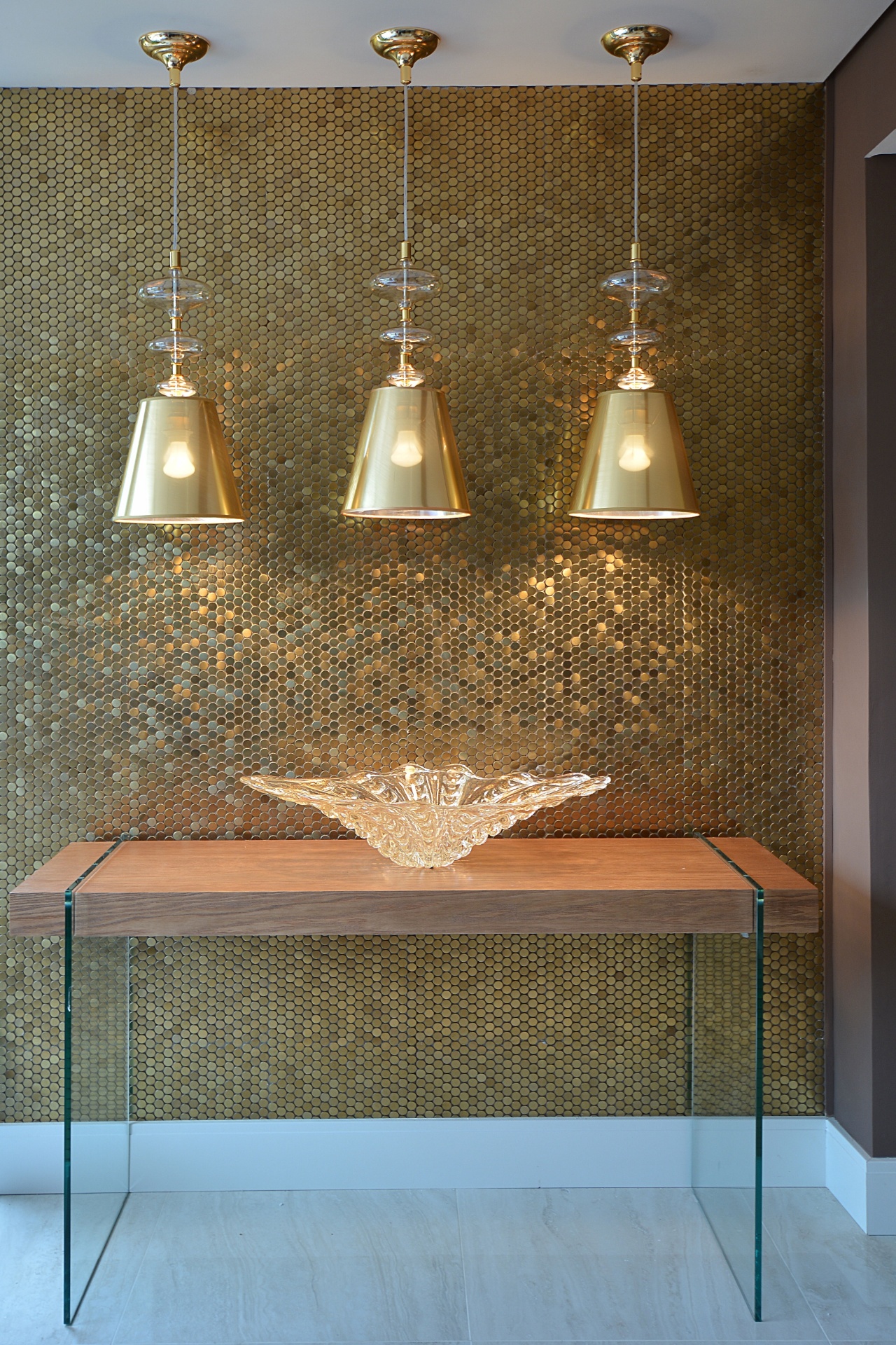 Os acabamentos dão um toque de sofisticação ao ambiente Chris Padilha In Casa Bonita como as pastilhas (Portobello) douradas em uma das paredes. As luminárias suspensas e o vaso de cristal murano sobre o aparador arrematam a composição luxuosa. A 23ª edição da Casa Cor RS fica em cartaz até dia 28 de setembro de 2014, na Rua Carlos Trein Filho, 930, em Porto Alegre. Outras informações: www.casacor.com.br/rs - Eduardo Liotti/Divulgação