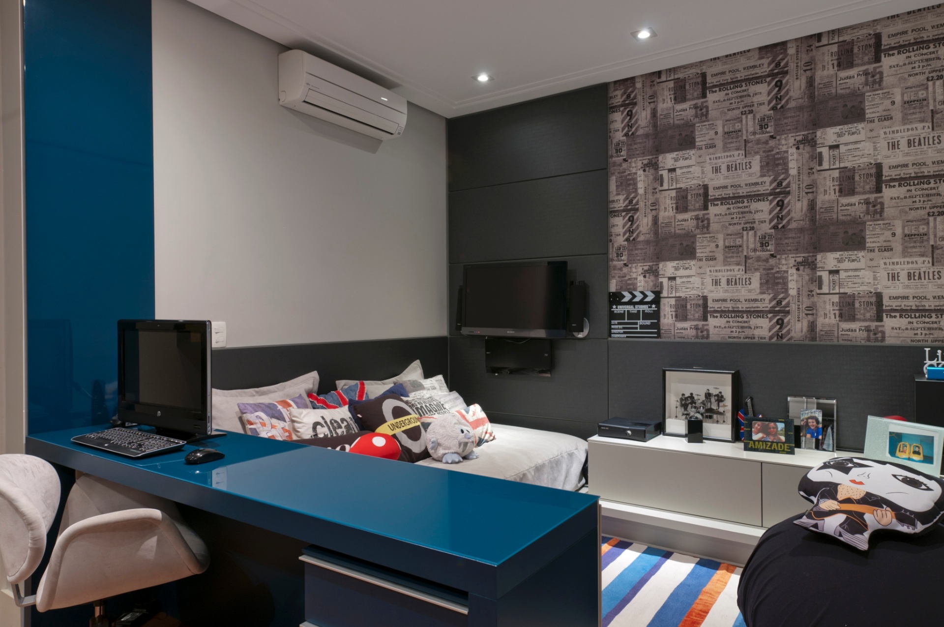 Elaborada em tons azul e cinza claro pela arquiteta Ana Bartira Brancante (www.anabartira.com.br) para um adolescente que precisava  de seu espaço para estudos e sossego, a decoração do quarto de 16 m² é composta pelo painel de tecido estampado com manchetes de jornal, almofadas com estampas de bandeiras e ícones urbanos jovens, todos remetendo à tradição da música inglesa. O tapete listrado também combina com o design, com tons de laranja para aquecer o ambiente - Raul Fonseca/Divulgação