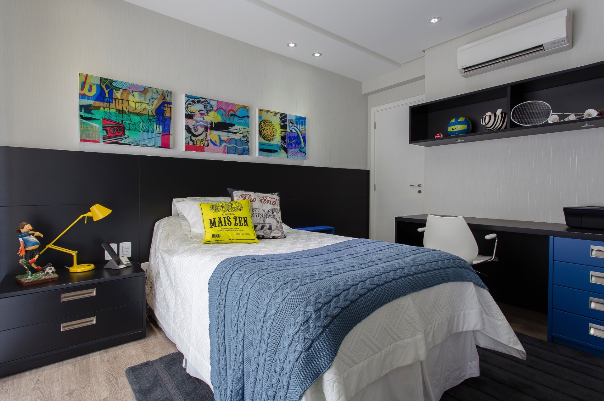 Em tons neutros, este dormitório planejado pela designer de interiores Ana Cristina Moral (11 2669-2186) destaca-se pela marcenaria executada pela Florense ABC (www.florense.com) que racionalizou o espaço de 9 m². Veja que tons de preto e azul repetem-se não só nos móveis como na cabeceira, quebrados pelo amarelo da almofada da luminária e o colorido dos quadros, que mais uma vez exibe a tendência da arte urbana - CAAD Fotografia/Divulgação
