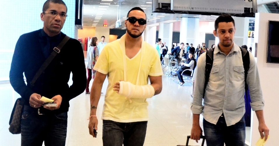 4.ago.2014 - O cantor Belo embarca com o braço enfaixado no aeroporto Santos Dumont, no Rio de Janeiro