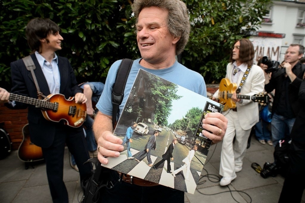 8.ago.2014 - Fã carrega o álbum "Abbey Road", com a icônica imagem dos integrantes dos Beatles atravessando a rua - Leon Neal/AFP Photo