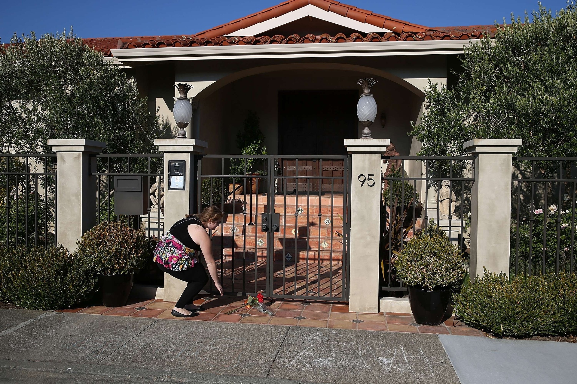 11.ago.2014 - Fã deixa flores no portão da casa de Robin Williams em Tiburon, na Califórnia, Estados Unidos. O ator foi encontrado morto nesta segunda-feira, com suspeita de asfixia - Justin Sullivan/Getty Images/AFP