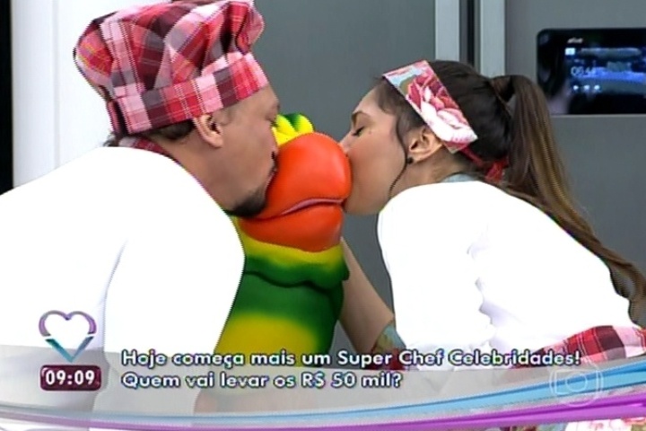 11.ago.2014 - Fabio Lago e Jéssika Alves beijam o papagaio Louro José. A atriz disse que seu sonho de infância era beijar o mascote de Ana Maria