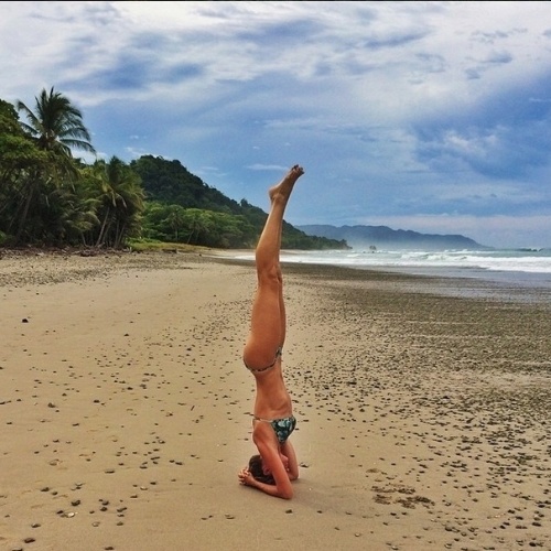A modelo Gisele Bundchen posa em praia fazendo uma das posições do ioga