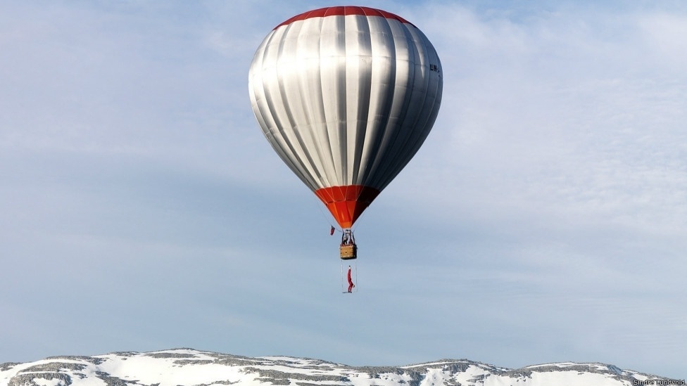 Flutuando com este balão dirigível por cima do povoado de Voss, na Noruega, o equilibrista fez malabarismos com um trapézio a 360 metros de altura - Eskil Ronninghbakken