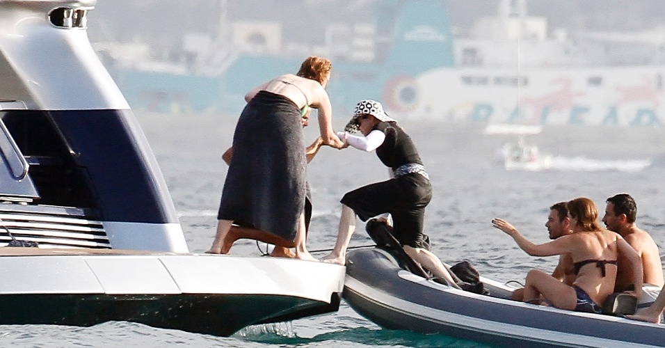 19.ago.2014 - Em Ibiza, na Espanha, Madonna recebe ajuda para passar de barco à iate