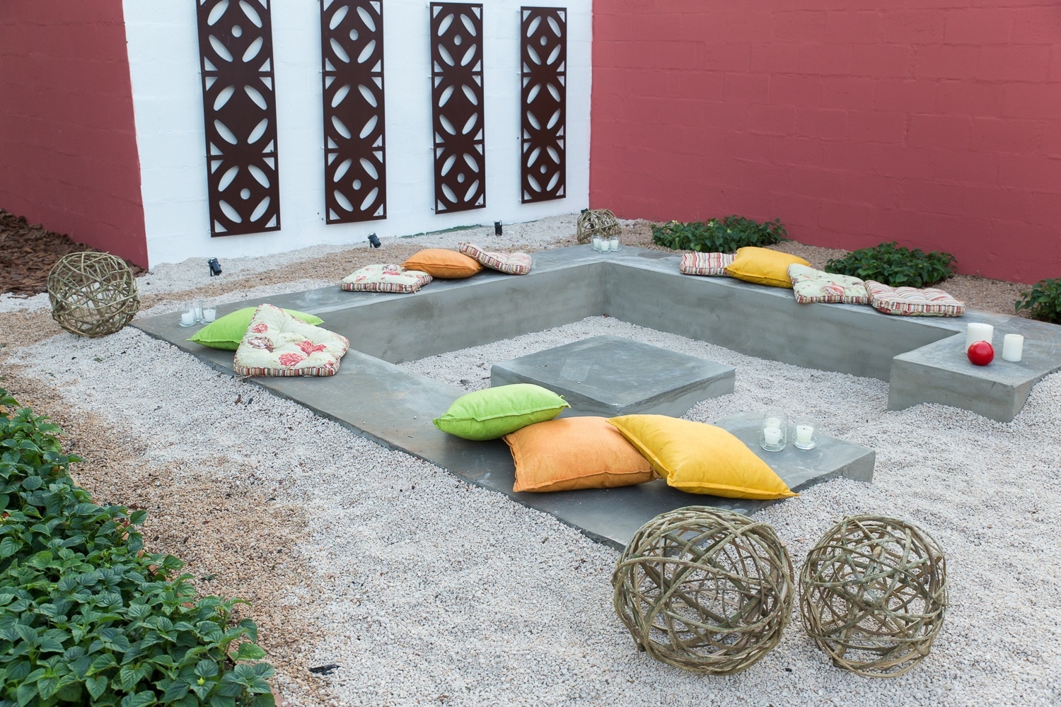 Detalhe do ambiente Natureza em Festa, criado por Juliana Catto e Mirella Sanches, para a Mostra de Paisagismo da Expoflora 2014. As arquitetas desenvolveram uma lareira de chão cercada por bancos e com acabamento de pedriscos. Nas paredes, as chapas de aço corten recebem a iluminação das labaredas e criam desenhos através das sombras - Divulgação