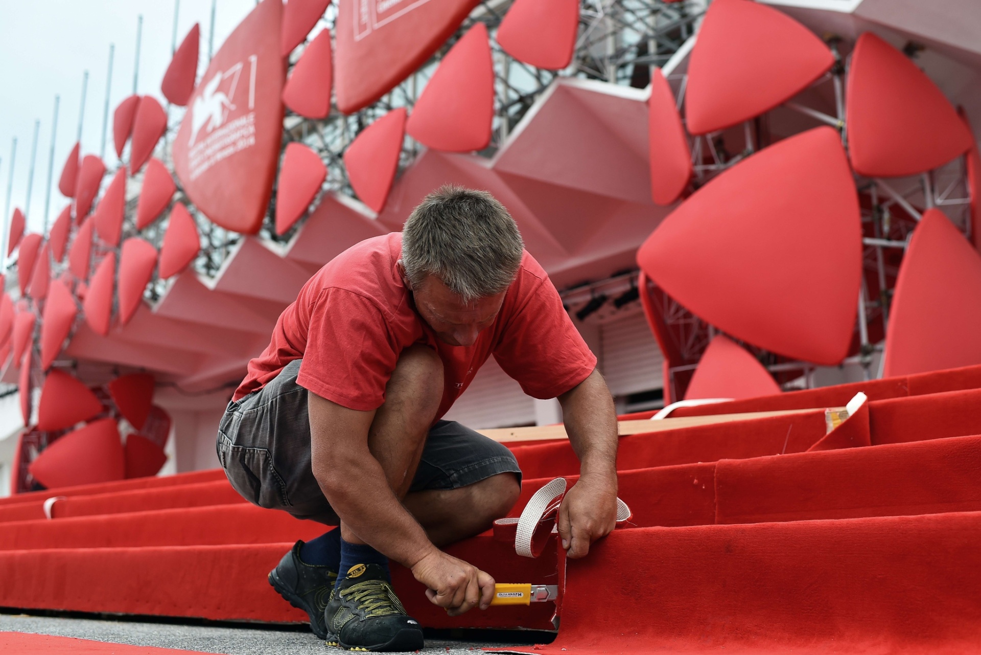 26.ago.2014 - Homem prega tapete vermelho em frente ao Lido Casino, um dia antes da abertura do Festival de Veneza - AFP