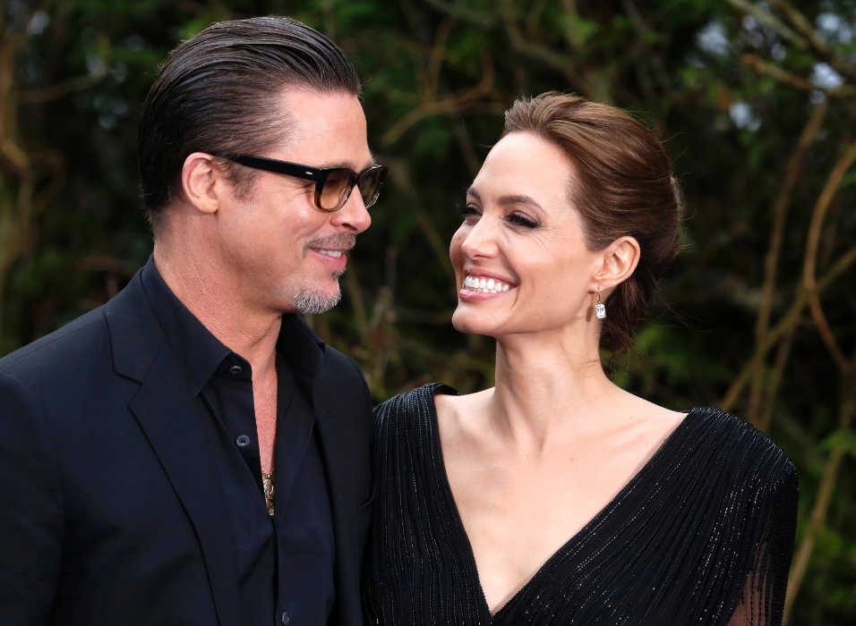 8.mai.2014 - Brad Pitt e Angelina Jolie sorriem ao chegar para exibição dos figurinos de "Malévola" no Palácio de Kensington, em Londres