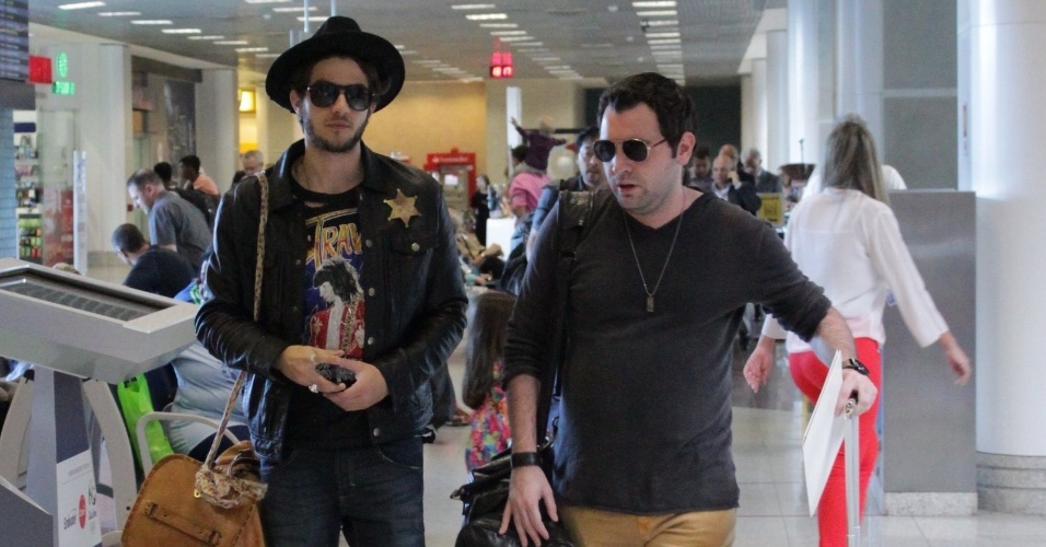 5.set.2014 - Chay Suede foi visto circulando no aeroporto Santos Dumont, no Rio de Janeiro, usando um traje inusitado, composto por uma jaqueta com uma estrela de xerife, chapéu e uma calça justa