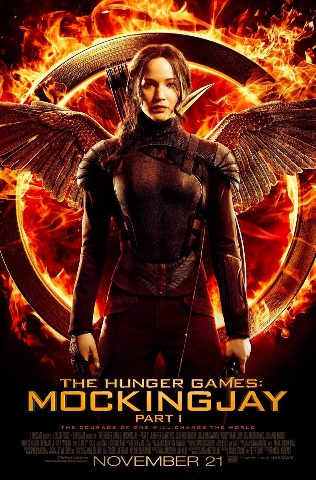 Katniss Everdeen (Jennifer Lawrence) aparece com seu uniforme de líder rebelde no primeiro pôster oficial de "Jogos Vorazes: A Esperança - Parte 1", em frente ao seu símbolo, um tordo em chamas - Divulgação