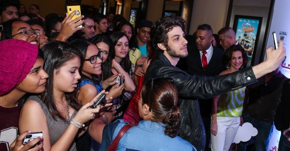 13.set.2014 - O cantor e ator Chay Suede faz selfiecom fãs na pré-estreia do filme "Lascados", em São Paulo