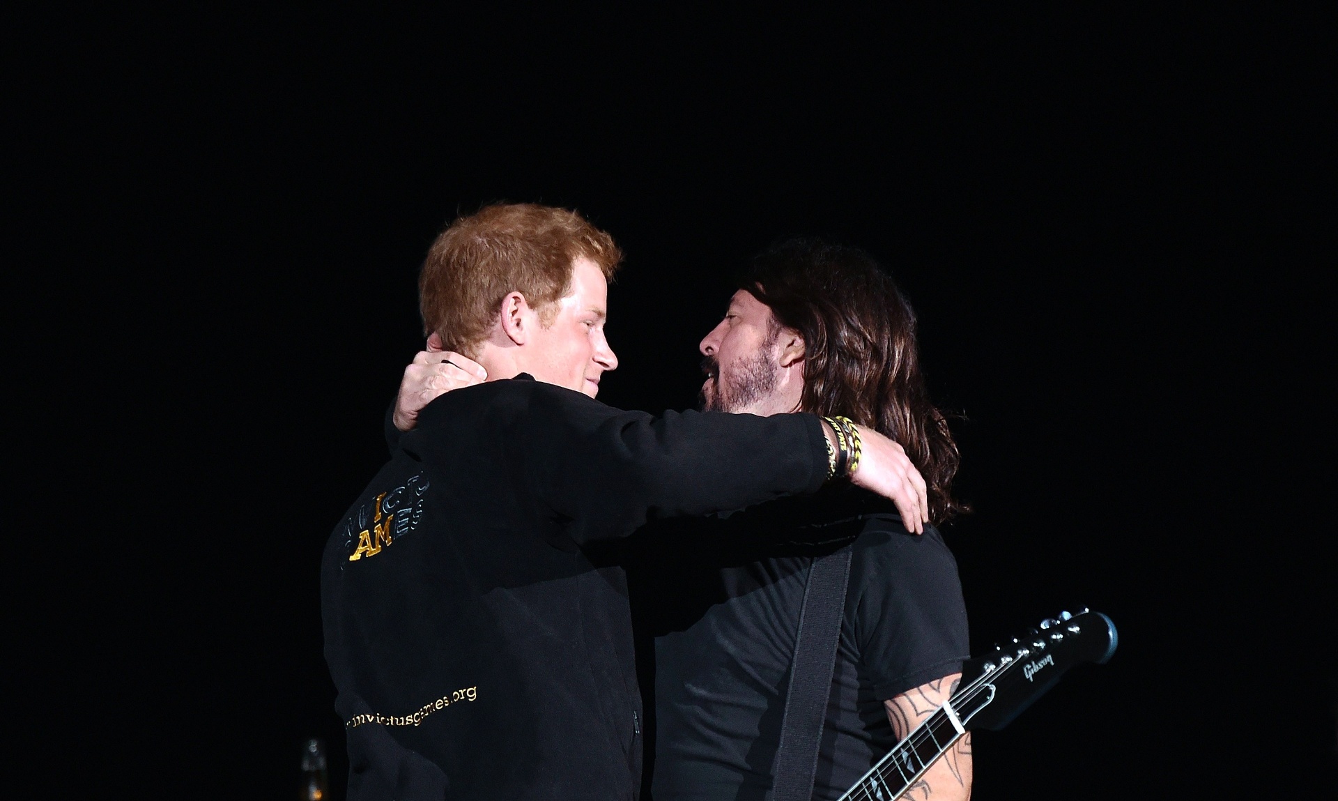 14.set.2014 - Príncipe Harry abraça Dave Grohl no palco, durante show do Foo Fighters no no Olympic Park, em Londres - REUTERS/Toby Melville