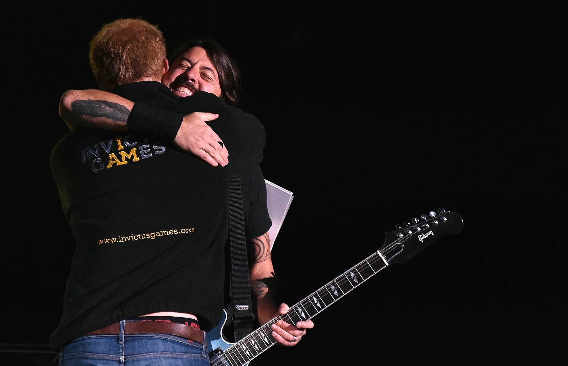 14.set.2014 - Príncipe Harry apresenta show do Foo Fighters, no encerramento do Invictus Games, em Londres, e abraça Dave Grohl no palco - REUTERS/Toby Melville