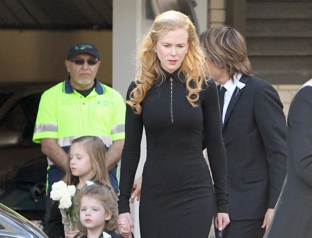 De mãos dadas com a filha Faith, Nicole Kidman chega para o velório de seu pai