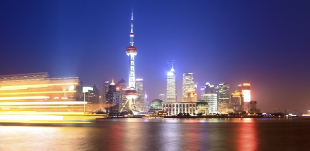 Navio cruza as águas de Xangai à noite; cidade é destino de cruzeiros na Ásia - Getty Images