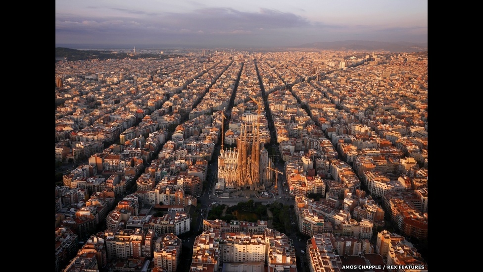 As torres da igreja inacabada de Antoni Gaudi, a Sagrada Família - uma basílica na cidade de Barcelona, na Espanha - se destacam na vista aérea do distrito Eixample - Amos Chapple/Rex Features