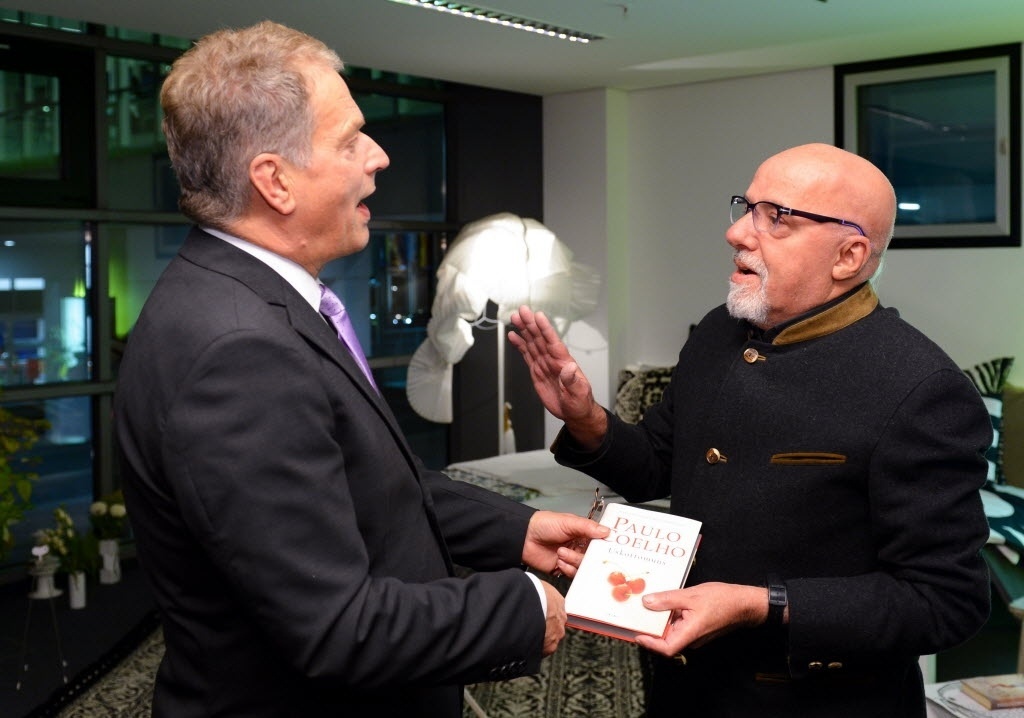 07.out.014 - O presidente da Finlândia, Sauli Niinisto, e o escritor Paulo Coelho conversam durante abertura da Feira do Livro de Frankfurt - AFP