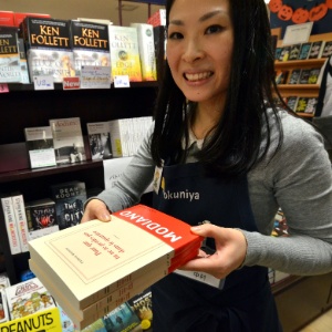 9.out.2014 - Vendedora de livraria em Tóquio mostra obra de Patrick Modiano, vencedor do Nobel de Literatura - Yoshikazu Tsuno/AFP